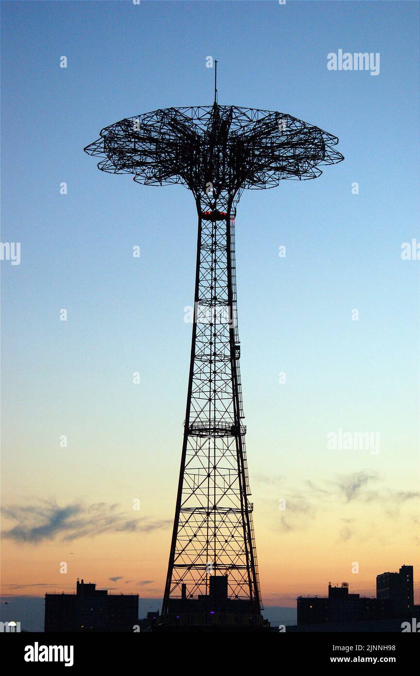 Le nouveau trajet en parachute dormant et inopérable sur la promenade de Coney Island est rendu en silhouette contre le ciel du coucher du soleil à Brooklyn Banque D'Images