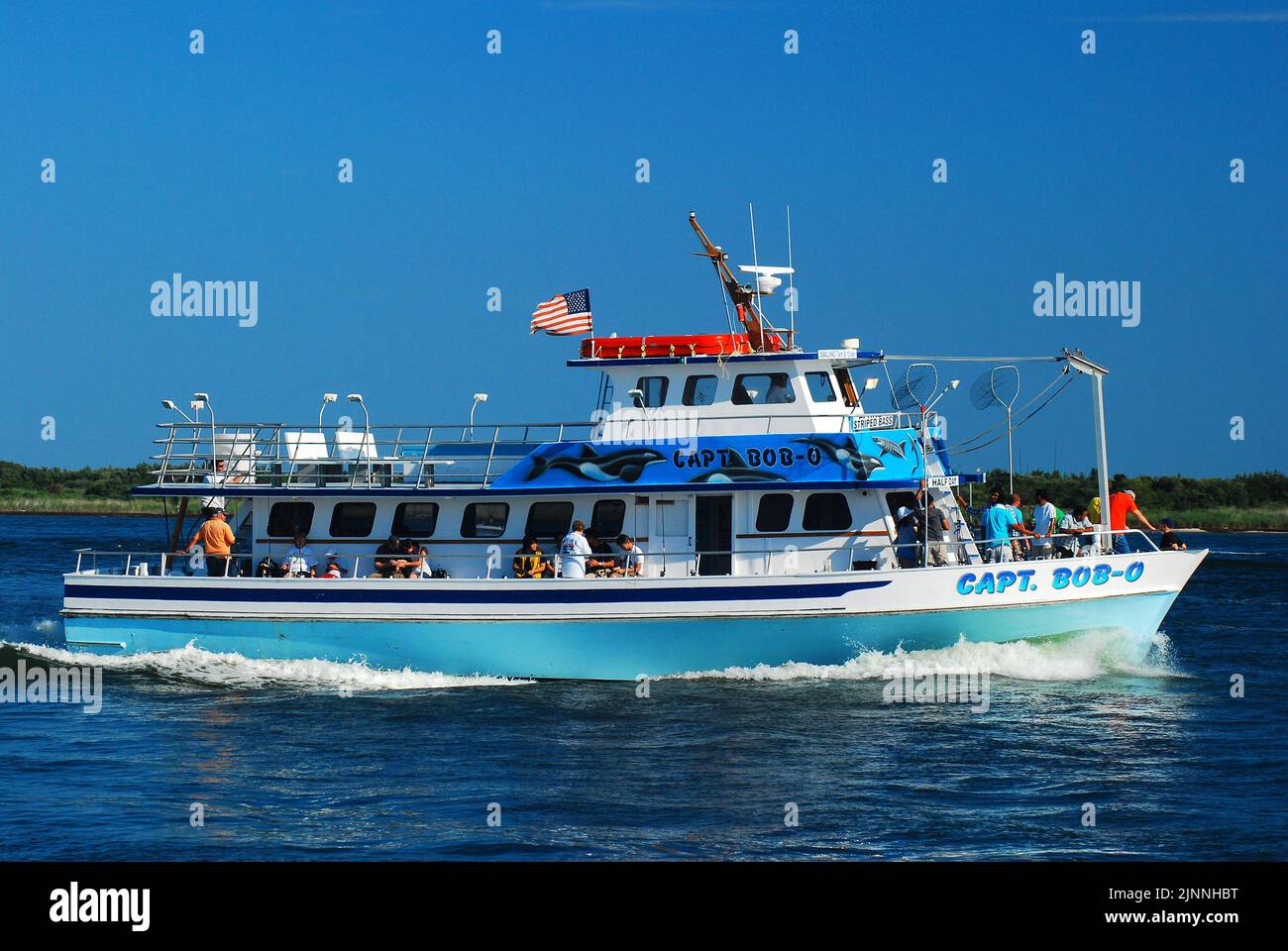 Le bateau de pêche affrété, le capitaine Bob O, quitte le port et se dirige vers les mers ouvertes lors d'une journée ensoleillée de vacances d'été Banque D'Images