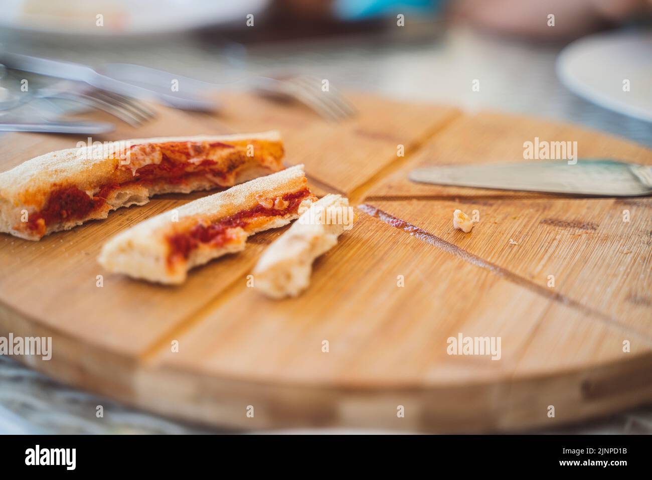 Restes de nourriture, beaucoup de croûtes de pizza sur un plateau rond en bois. Photo de haute qualité Banque D'Images