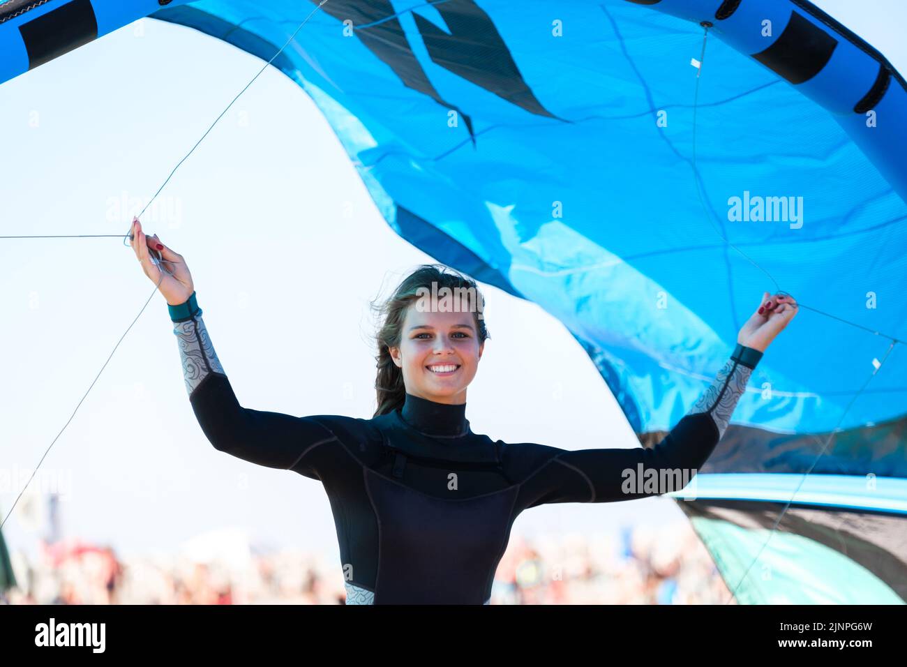 Belle fille de surf cerf-volant en maillot de bain rose, tenant un cerf-volant dans sa main debout sur la plage pour une bonne session de kiteboard. Banque D'Images
