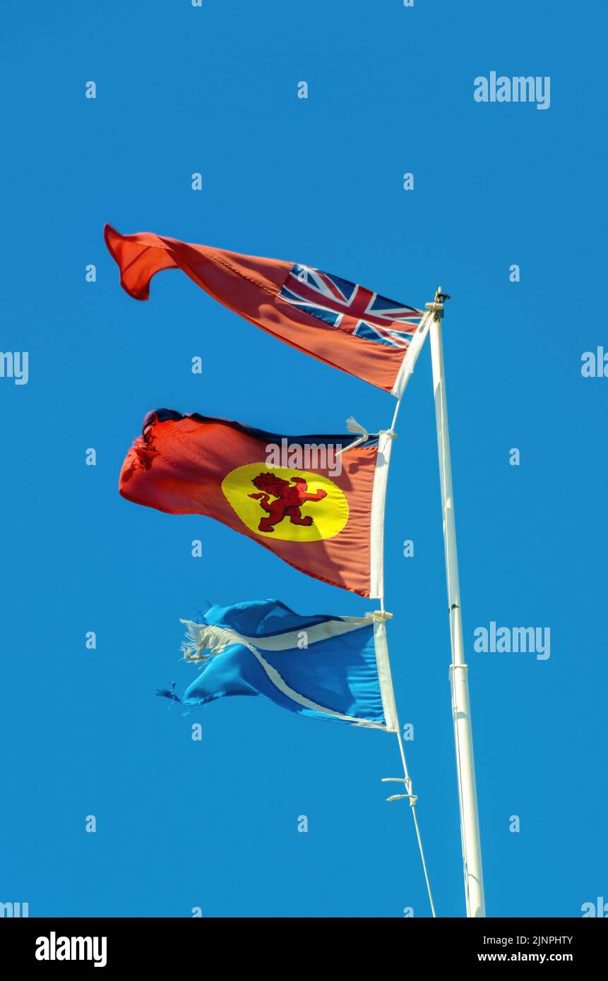 Le Red Ensign, le drapeau de la maison et Scottish Saltyre volant d'un ferry calédonien MacBrayne. Banque D'Images