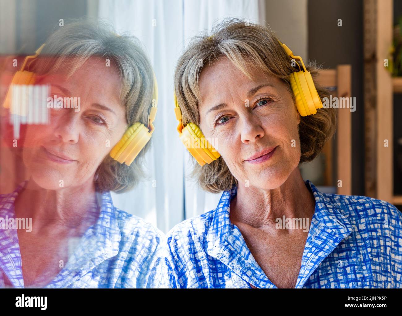 Belle femme mature sénior à la maison, la vie domestique et les loisirs - 50-60 ans jolie femme femme femme femme au foyer écoutant de la musique avec le headphon Banque D'Images