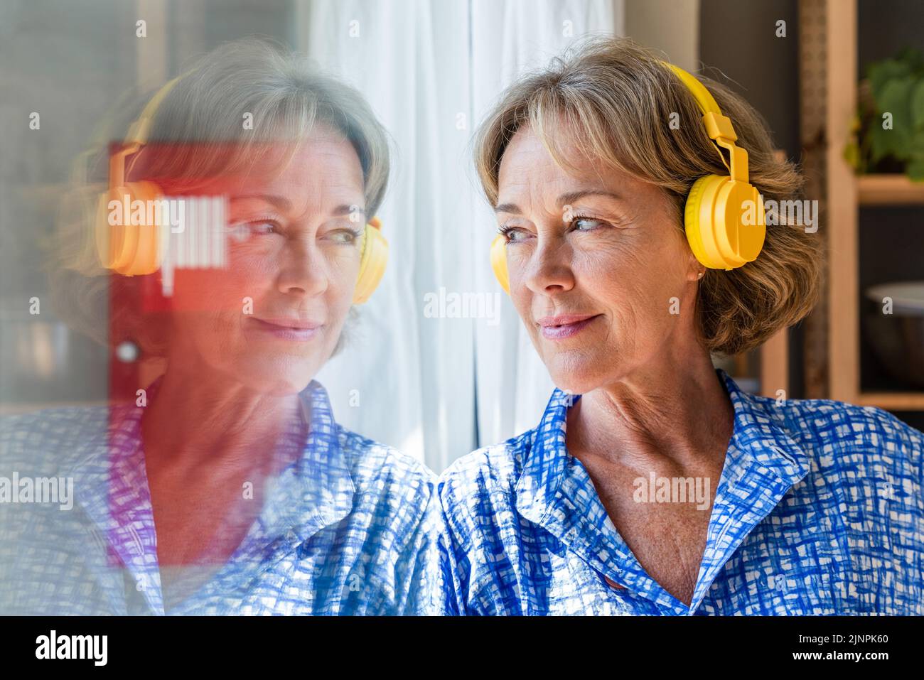Belle femme mature sénior à la maison, la vie domestique et les loisirs - 50-60 ans jolie femme femme femme femme au foyer écoutant de la musique avec le headphon Banque D'Images