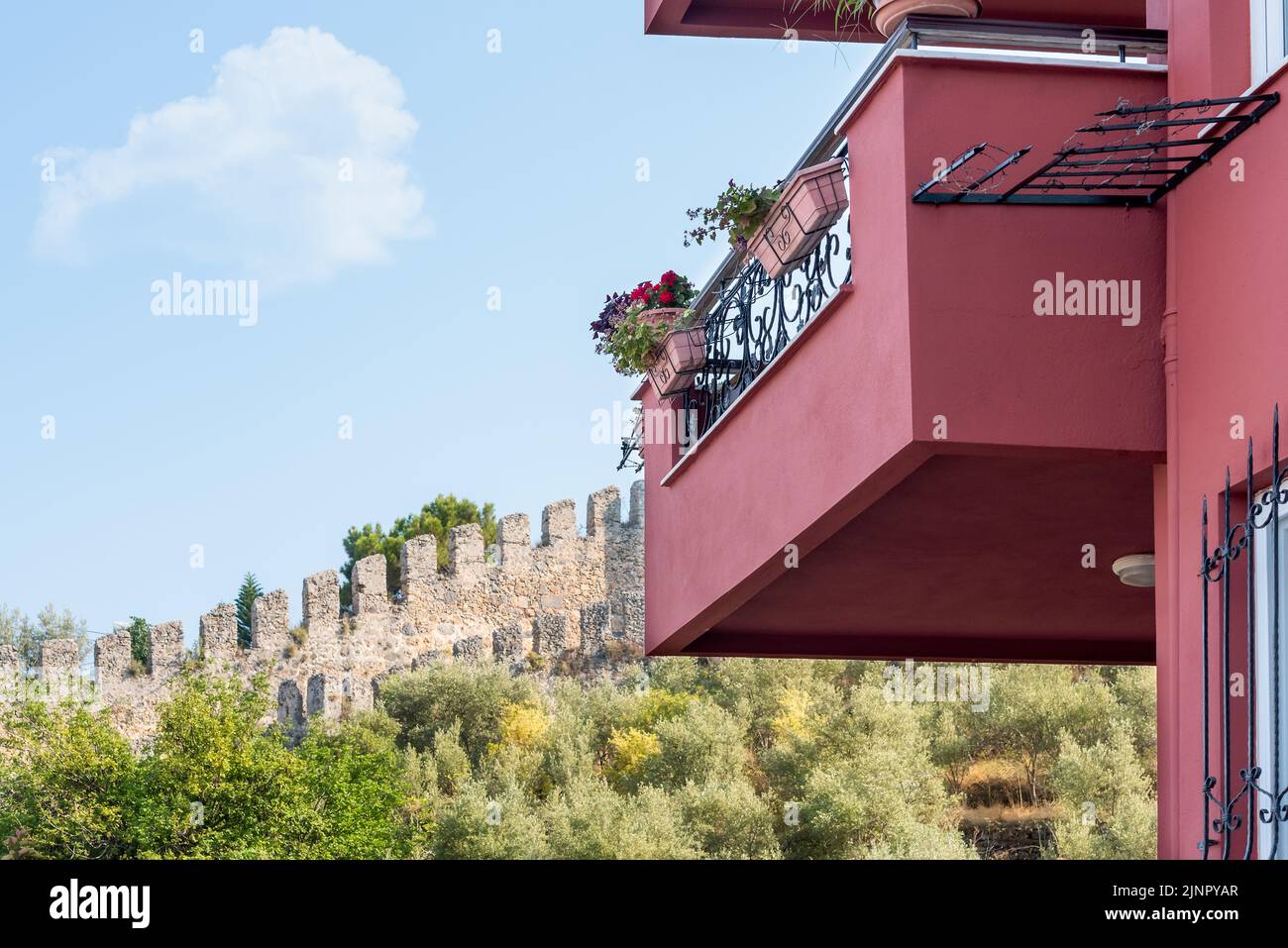 Partie d'un balcon rouge foncé avec une belle vue sur le mur de la forteresse à Alanya. Banque D'Images