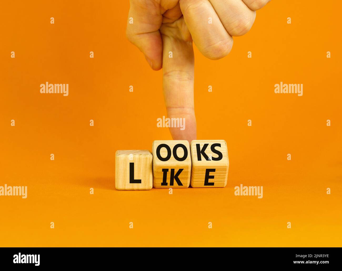 Ressemble à un symbole. Les mots concept ressemblent à des cubes en bois. Main d'homme d'affaires. Belle table orange fond orange. Affaires, citations populaires et Banque D'Images