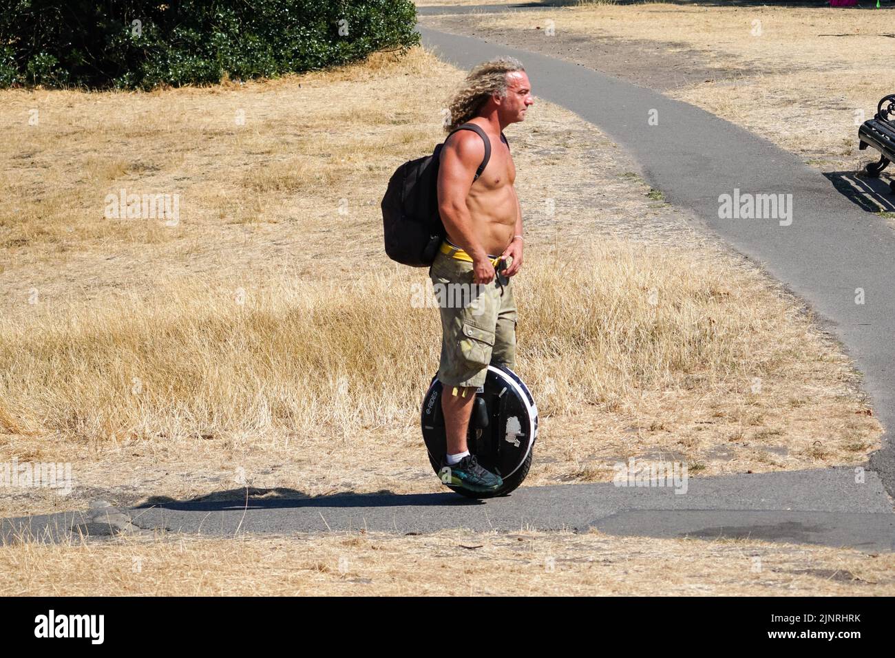Londres, Royaume-Uni. 13th août 2022. Météo au Royaume-Uni : un homme sur un monocycle électrique dans un parc sec de Greenwich à Londres. Credit: Marcin Rogozinski/Alay Live News Banque D'Images