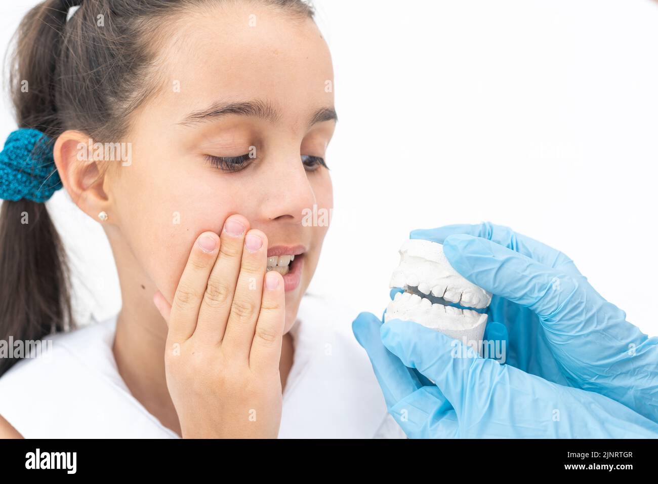 Le dentiste vérifie et définit la dimension des supports. Parler à une fille d'accolades dans sa bouche Banque D'Images