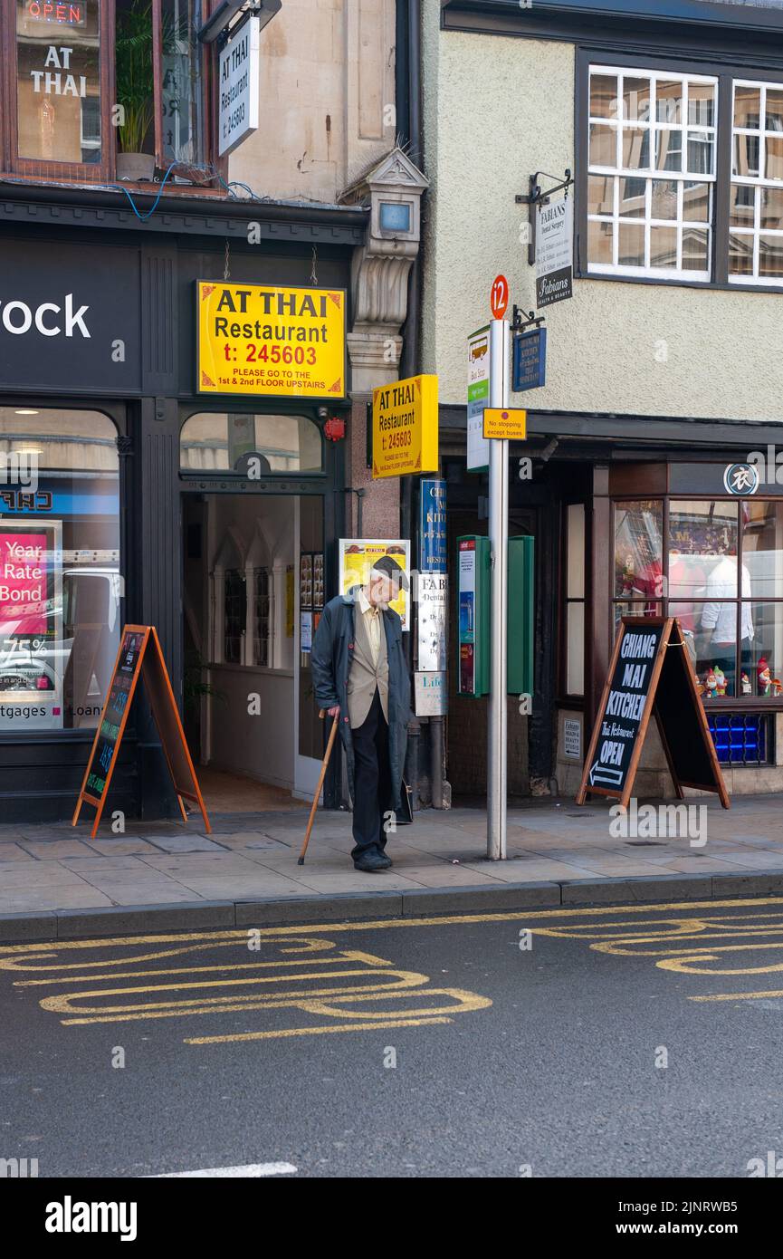 Un senior gentleman attend à l'arrêt de bus d'Oxford Banque D'Images