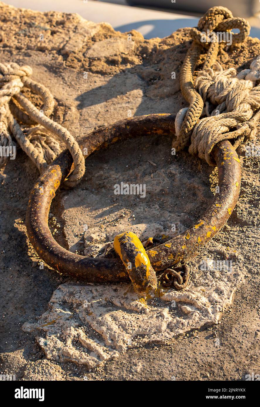 anneau de fer et vieux cordes sur un quai pour attacher et amarrer des navires et des bateaux le long du mur du port, amarrer anneau sur un quai vieux cordes. Banque D'Images