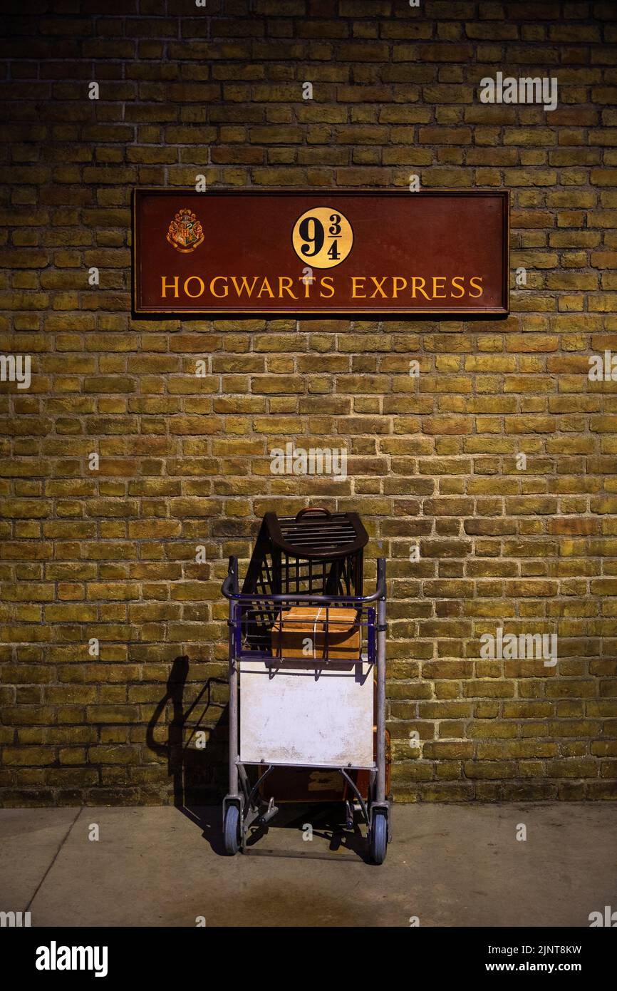 Londres, Royaume-Uni - 10 juin 2022 : chariot de magicien avec des paquets passant par le mur à Platform 9 3-4, Harry Potter Studio, Londres Banque D'Images