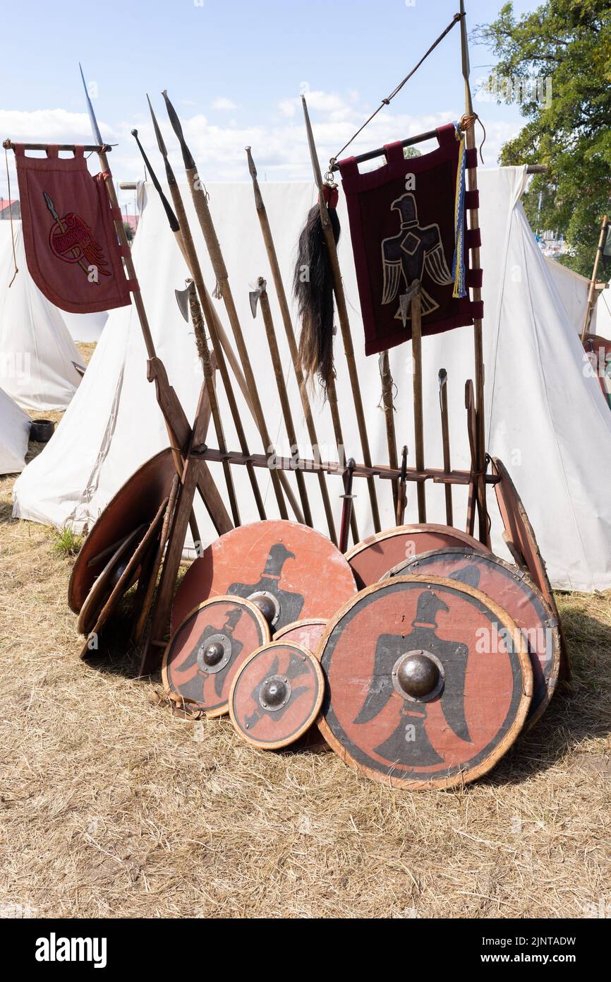 WOLIN, POLOGNE - 6 AOÛT 2022 : XXVII Festival des Slaves et Vikings, boucliers viking rouges et noirs et lances debout près de la tente Banque D'Images