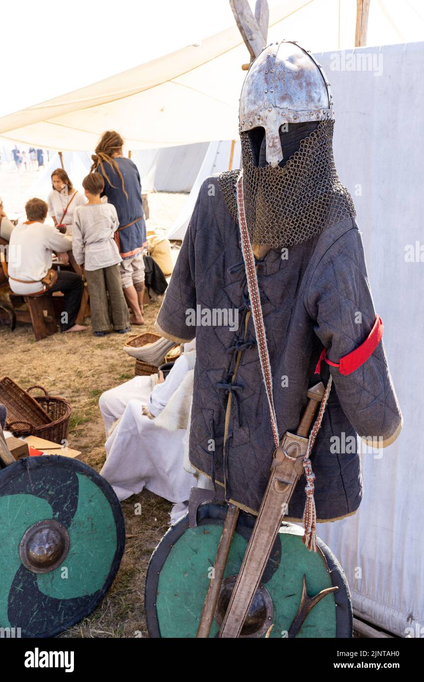 WOLIN, POLOGNE - 6 AOÛT 2022 : XXVII Festival des Slaves et Vikings, armure en tissu bleu, casque Viking et boucliers ronds verts Banque D'Images