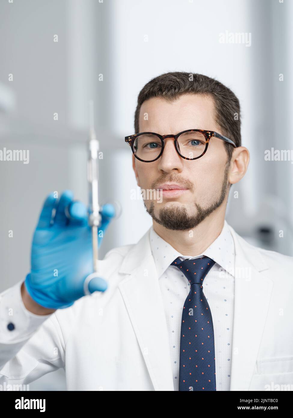 Gros plan d'un médecin portant une seringue à cartouche Banque D'Images