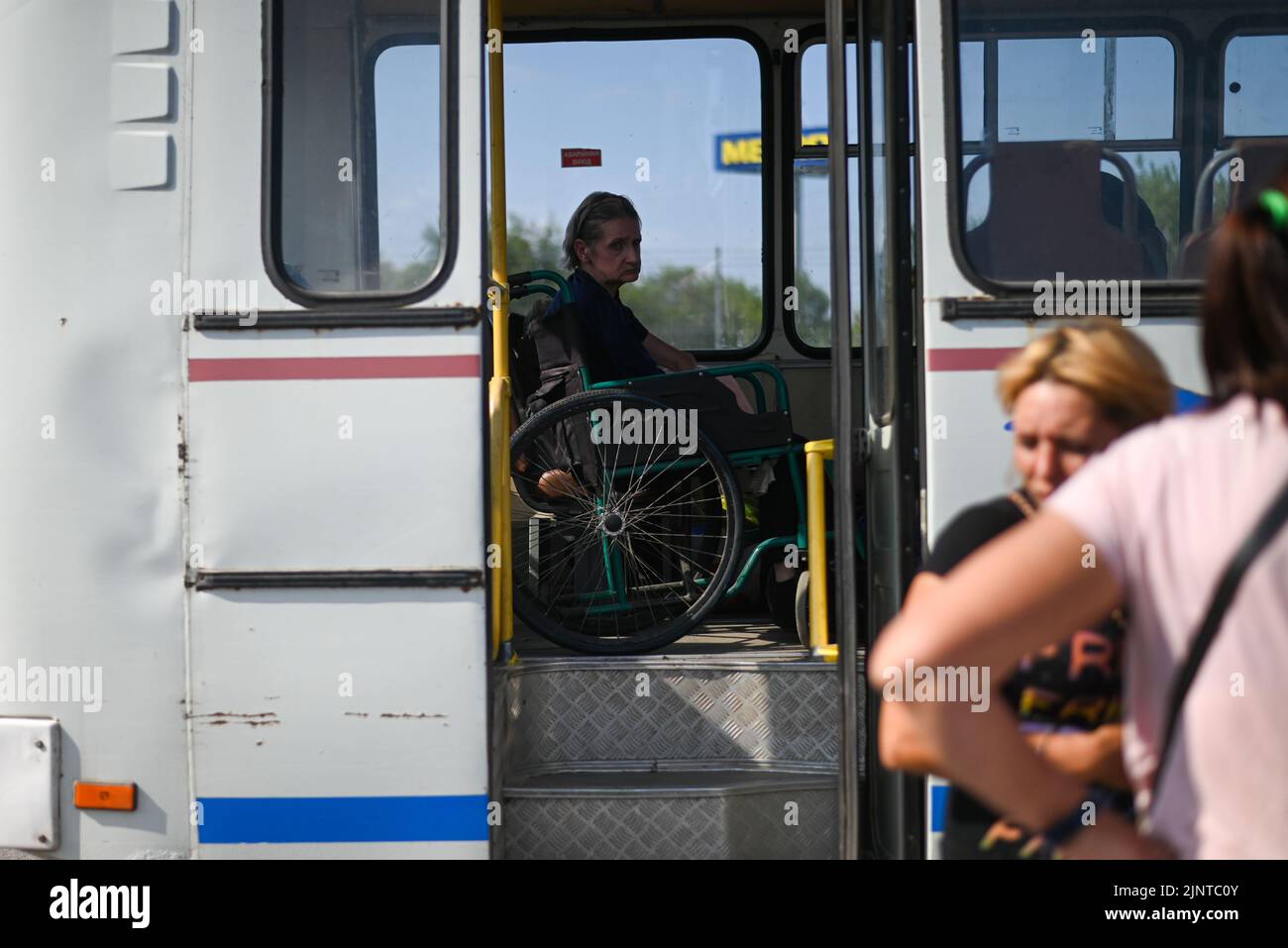 Ukraine. 13th août 2022. Natalia, une personne déplacée en fauteuil roulant du village russe occupé de Rozivka, s'assoit dans un bus tandis que d'autres personnes autour de lui débarquent à 13 août 2022. Les personnes déplacées à l'intérieur de l'Ukraine occupée par la Russie arrivent dans un centre d'accueil dans la ville de Zaporizhia, tandis que les bombardements s'intensifient dans la région. Zaporizhia, Ukriane. (Photo par Justin Yau/ Credit: SIPA USA/Alay Live News Banque D'Images