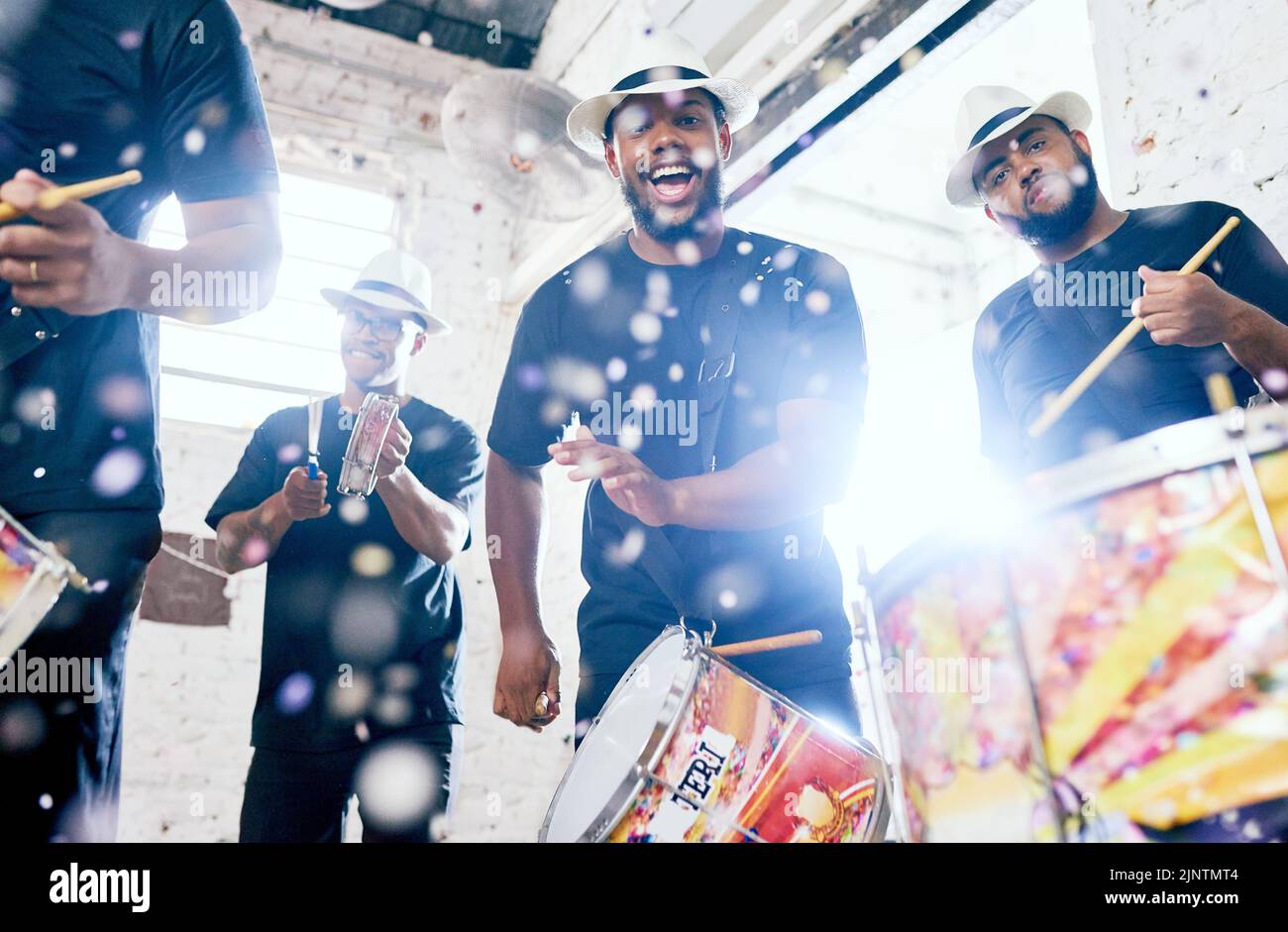 Bien fournir l'énergie. Portrait à angle bas d'un groupe de jeunes hommes de tambours de belle jouant au Carnaval. Banque D'Images