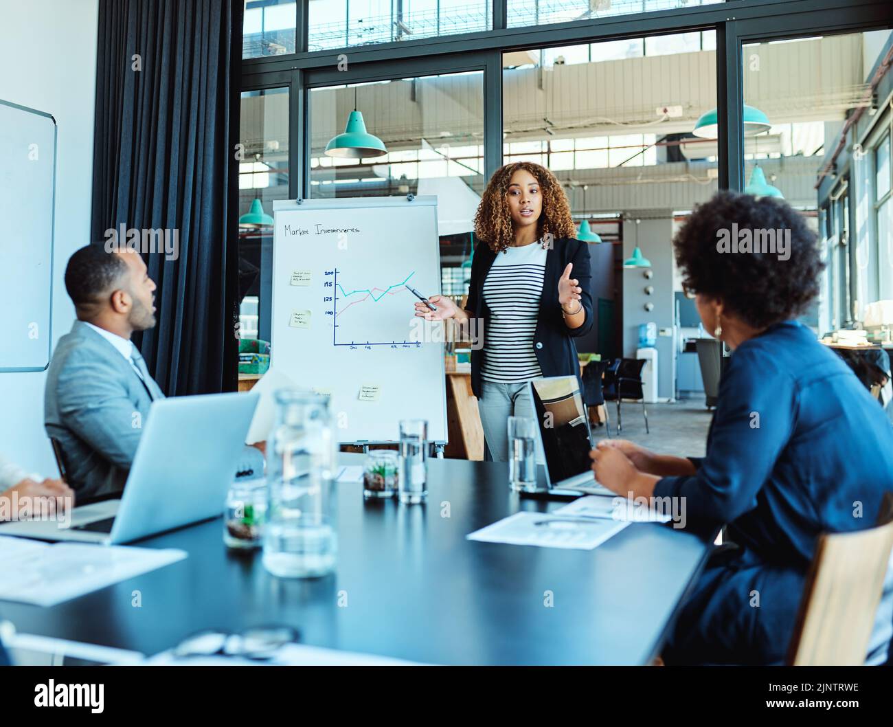 Planification de leur plus grand succès à ce jour. Une femme d'affaires qui donne une présentation à ses collègues dans un bureau. Banque D'Images