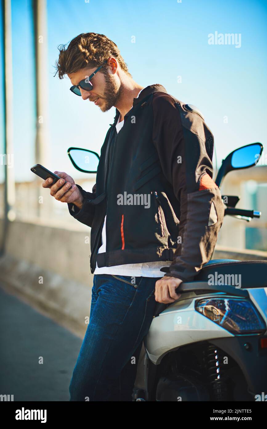 Rencontrez-moi pour une promenade à travers la ville. Un jeune homme qui fait une moto à travers la ville. Banque D'Images