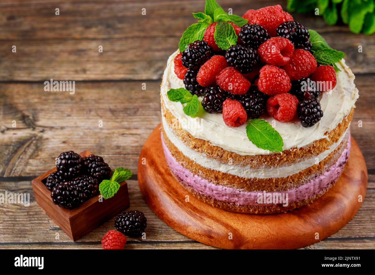 Un gâteau recouvert de framboises fraîches et de mûres. Banque D'Images