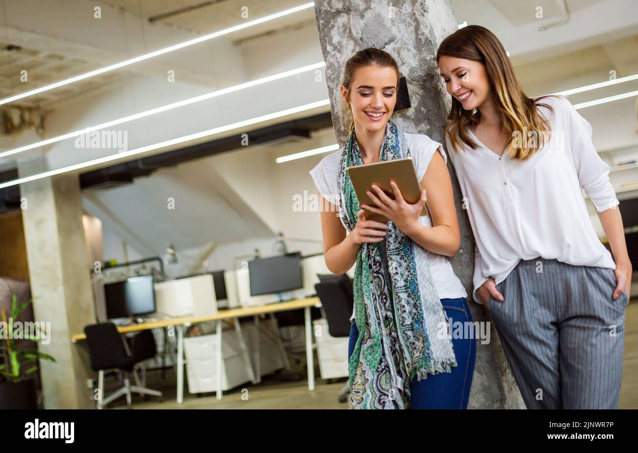 Une femme d'affaires attirante qui a une conversation amusante avec un collègue pendant une pause au bureau Banque D'Images