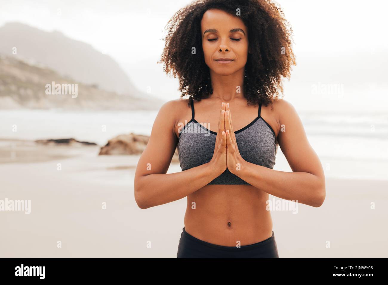 Portrait de la femme de fitness avec ses mains jointes. Jeune femme aux yeux fermés pratiquant la méditation de yoga. Banque D'Images