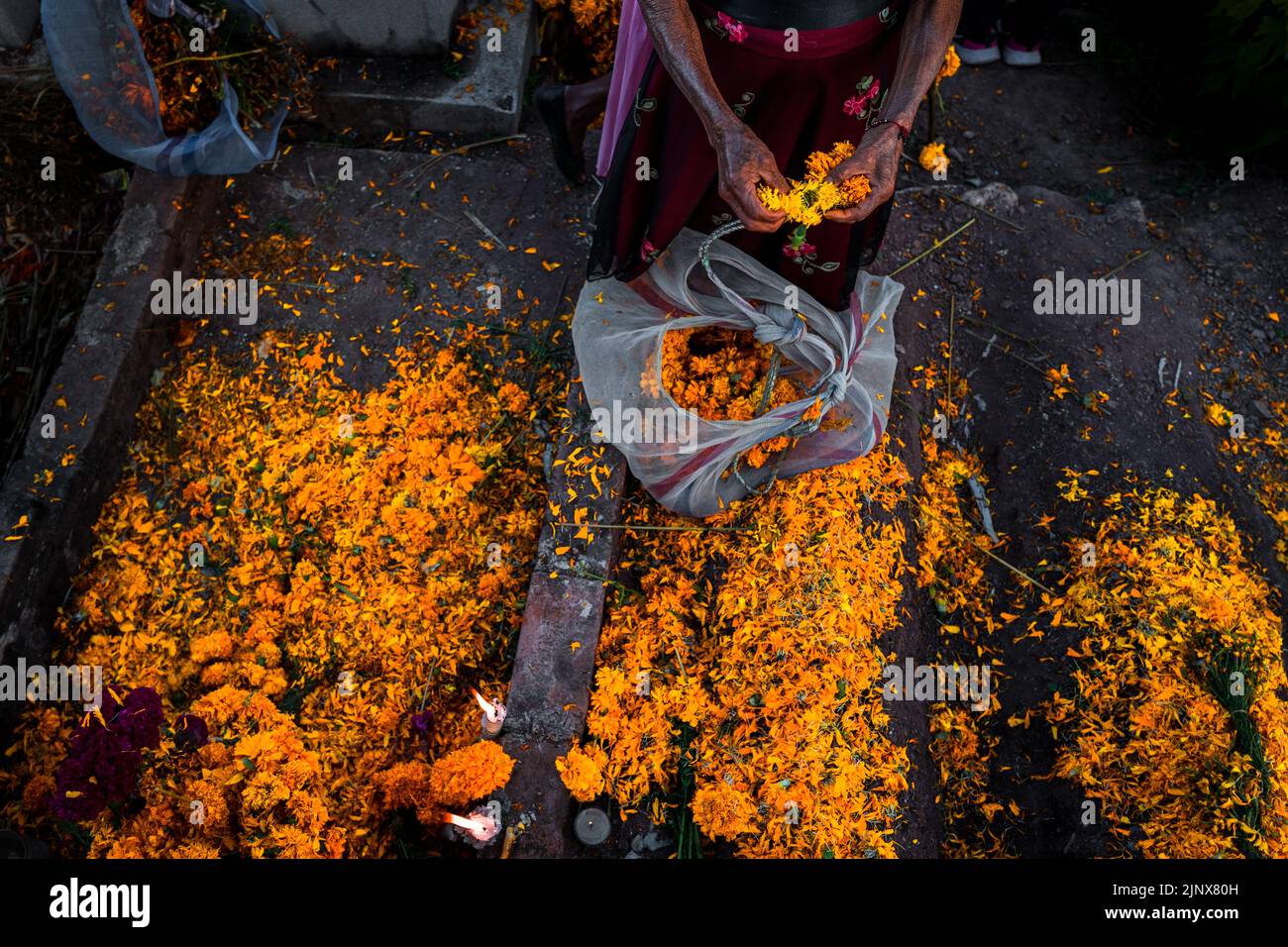 Une femme indigène Mixtec décore une tombe dans un cimetière lors des célébrations du jour des morts à Xalpatláhuac, Guerrero, Mexique. Banque D'Images