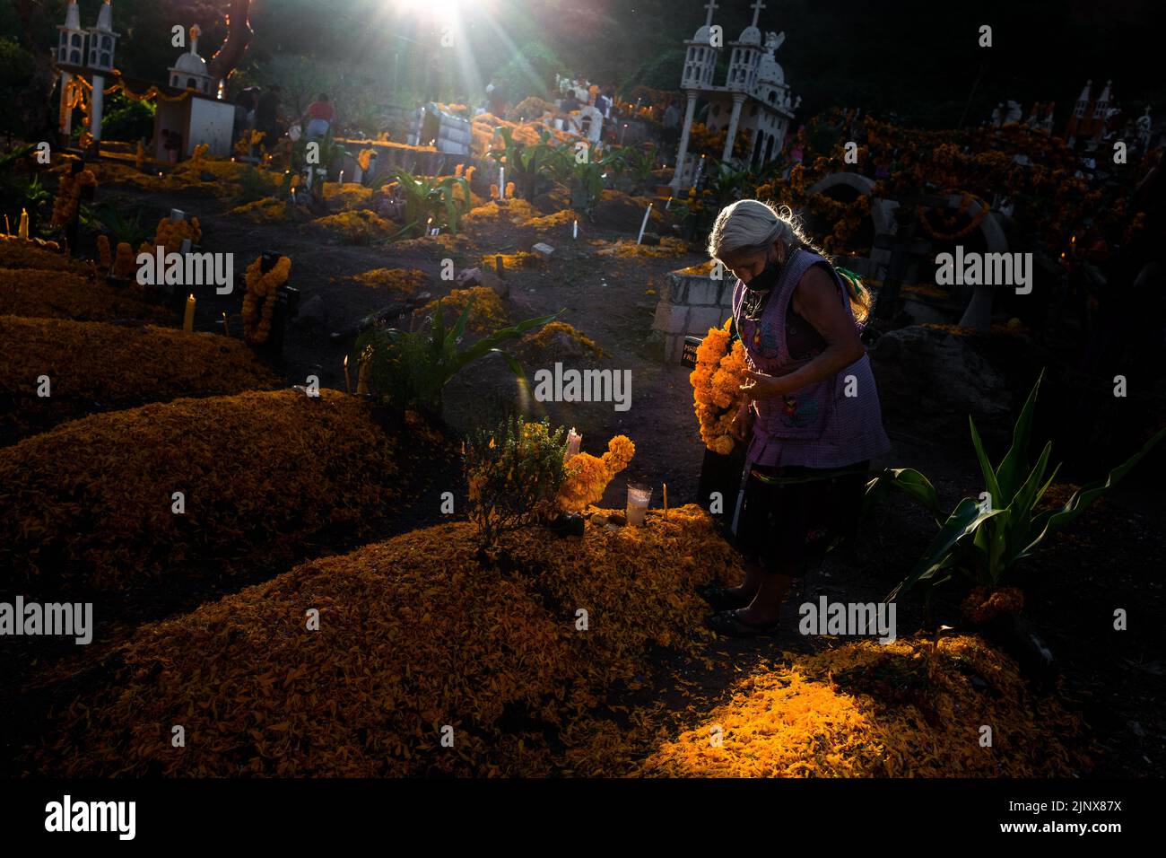 Une femme indigène Mixtec décore une tombe dans un cimetière lors des célébrations du jour des morts à Xalpatláhuac, Guerrero, Mexique. Banque D'Images