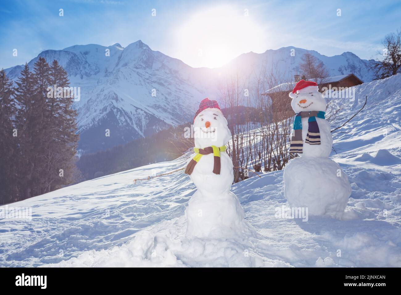 Deux bonhommes de neige avec chapeau de carotte et foulard sur les montagnes Banque D'Images
