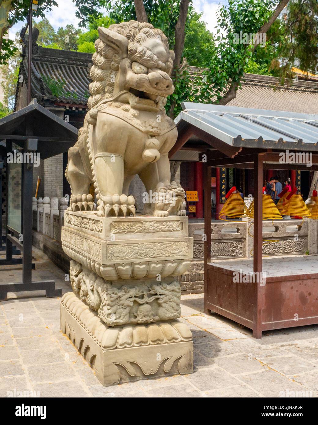 Sculpture d'un lion de pierre traditionnel chinois sur une place publique. Banque D'Images
