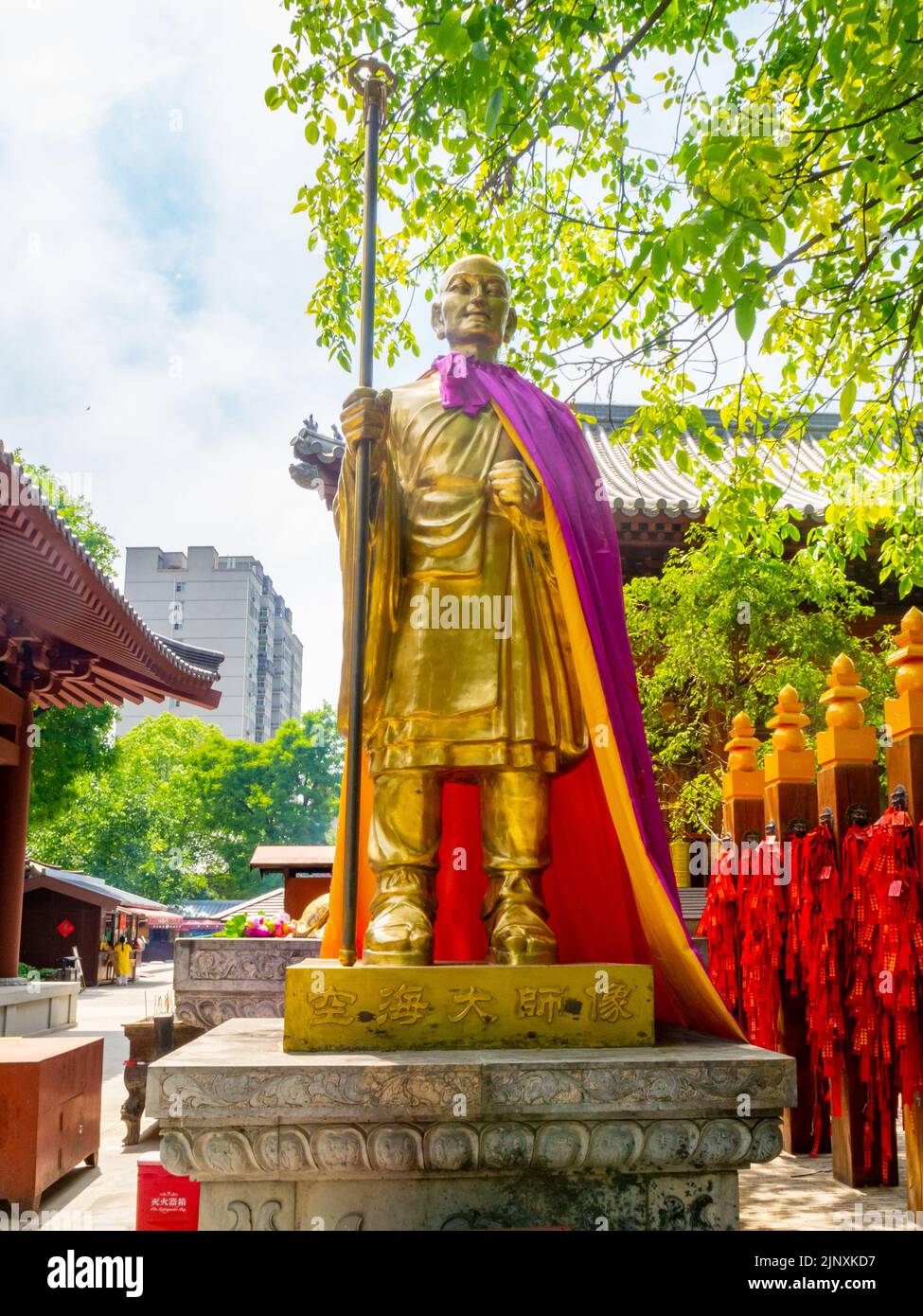 Statue ou sculpture religieuse chinoise dorée dans un parc public. Vue avant du symbole traditionnel. Banque D'Images