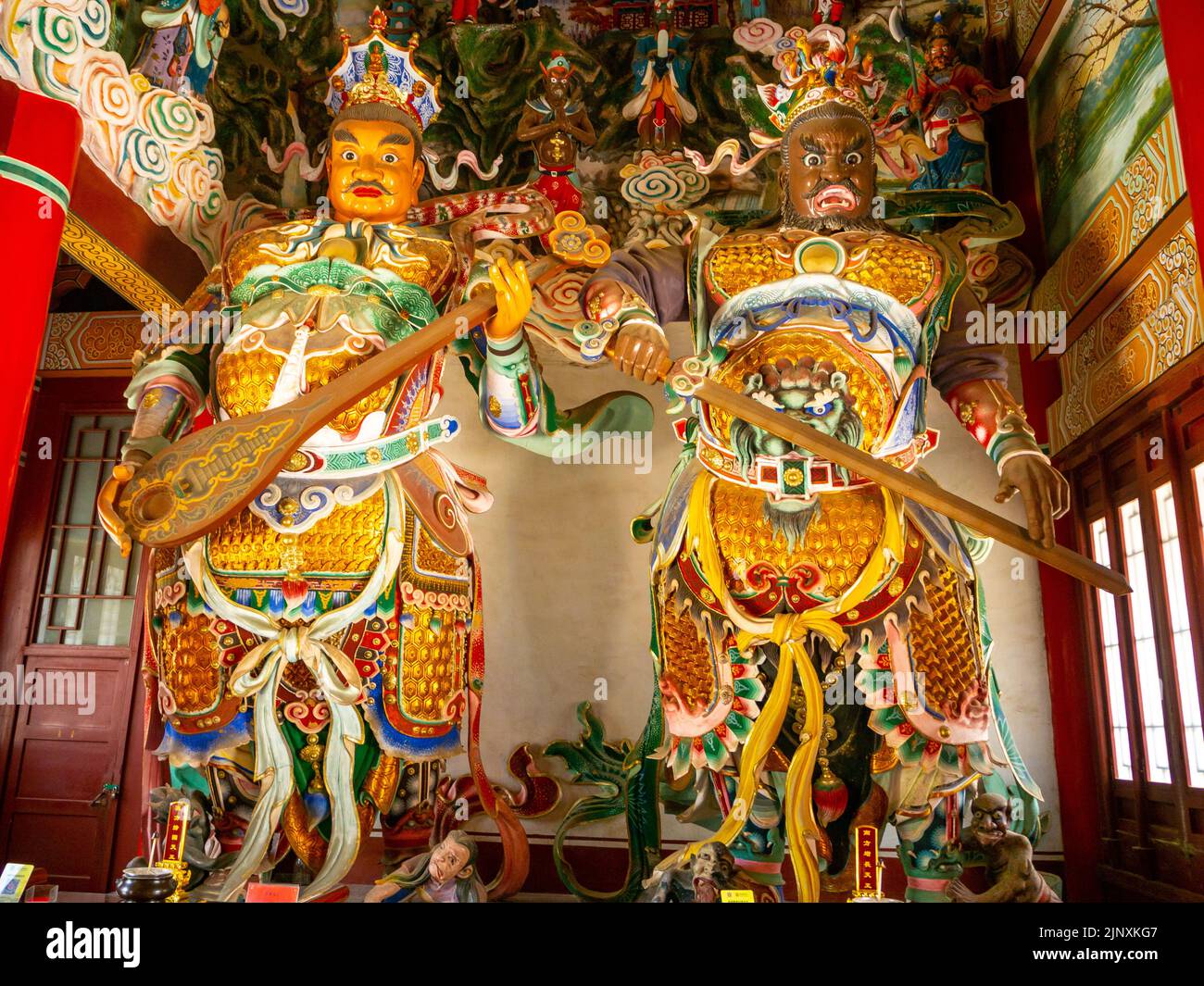 Deux statues religieuses traditionnelles chinoises à l'intérieur d'un temple. Les sculptures ont des vêtements multicolores. Banque D'Images