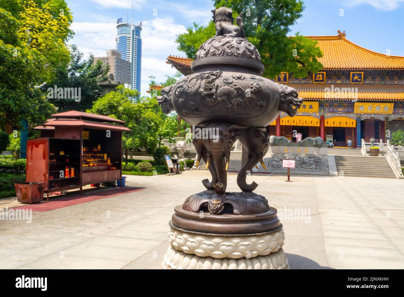 Ancienne sculpture métallique devant un bâtiment religieux traditionnel chinois. Le morceau d'art est situé dans une place ou plaza. Banque D'Images
