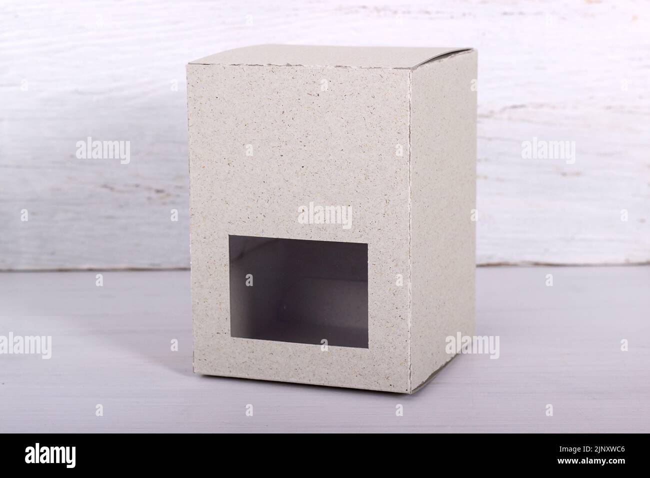 Emballage en carton clair avec fenêtre devant du bois clair Banque D'Images