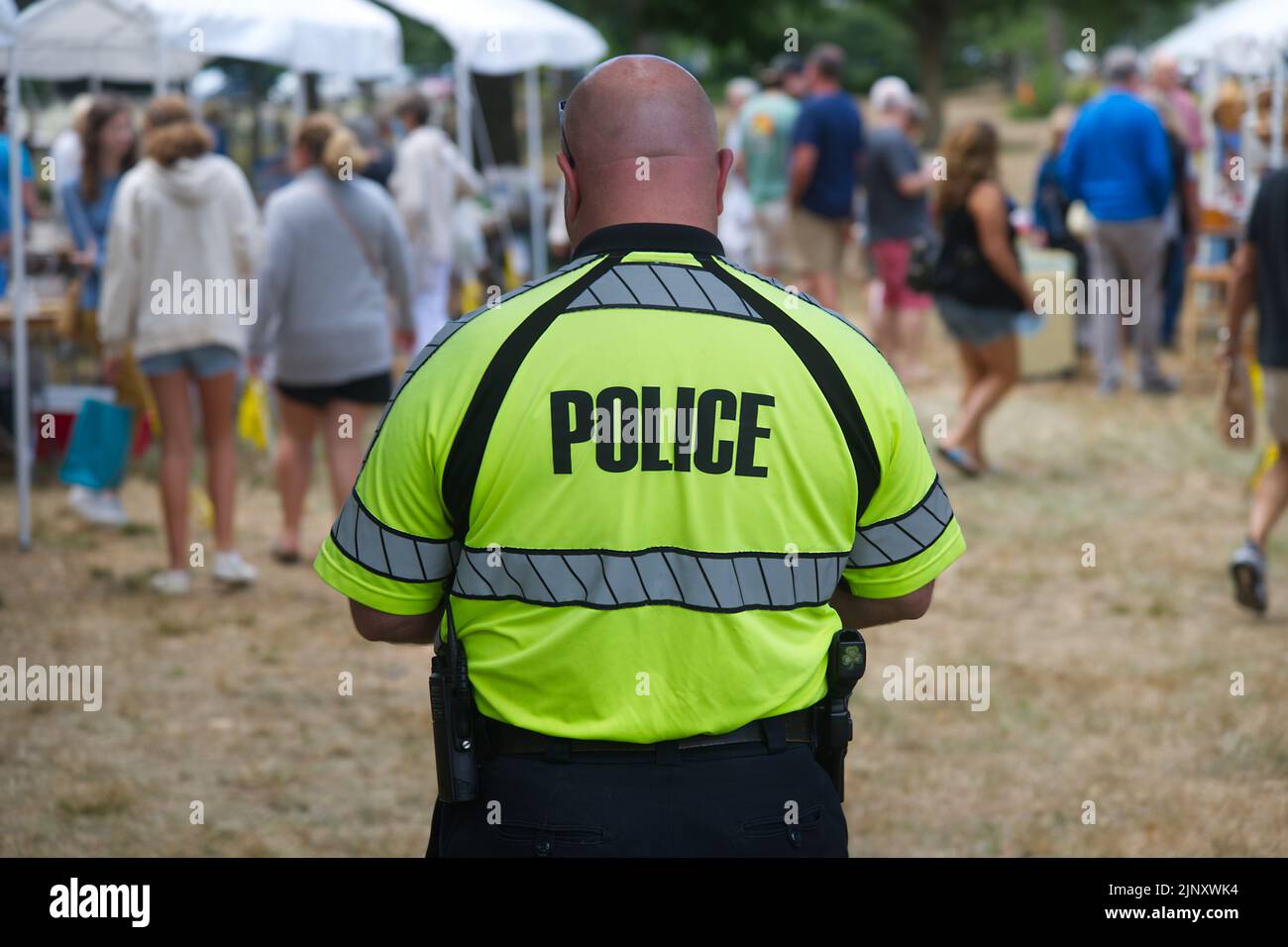 Un agent de police garde un oeil sur les choses à un marché aux puces d'église à Dennis, Massachusetts sur Cape Cod Banque D'Images