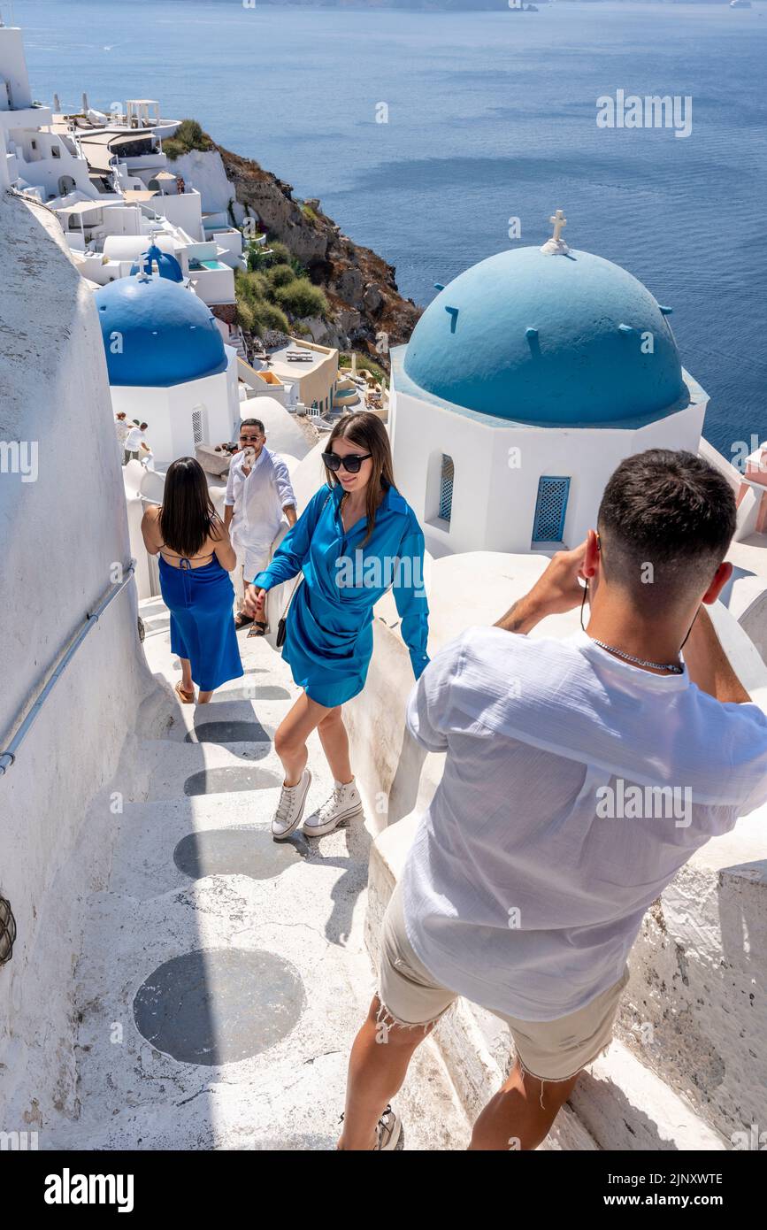 Jeunes posant pour des photos à Un point de vue classique dans la ville d'Oia, Santorin, les îles grecques, la Grèce. Banque D'Images