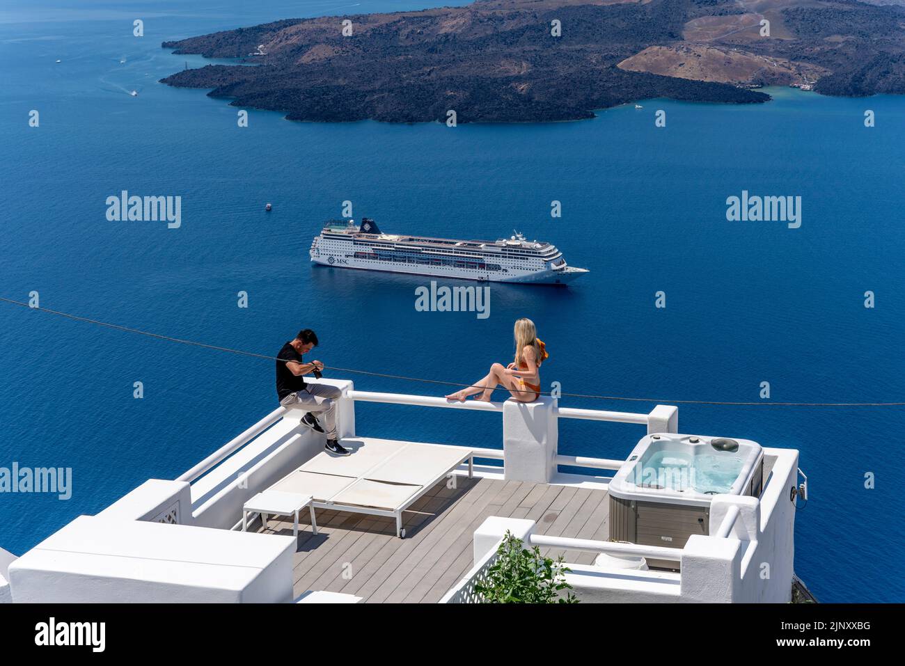 Une jeune femme pose pour une photo sur l'île de Santorini, les îles grecques, la Grèce. Banque D'Images