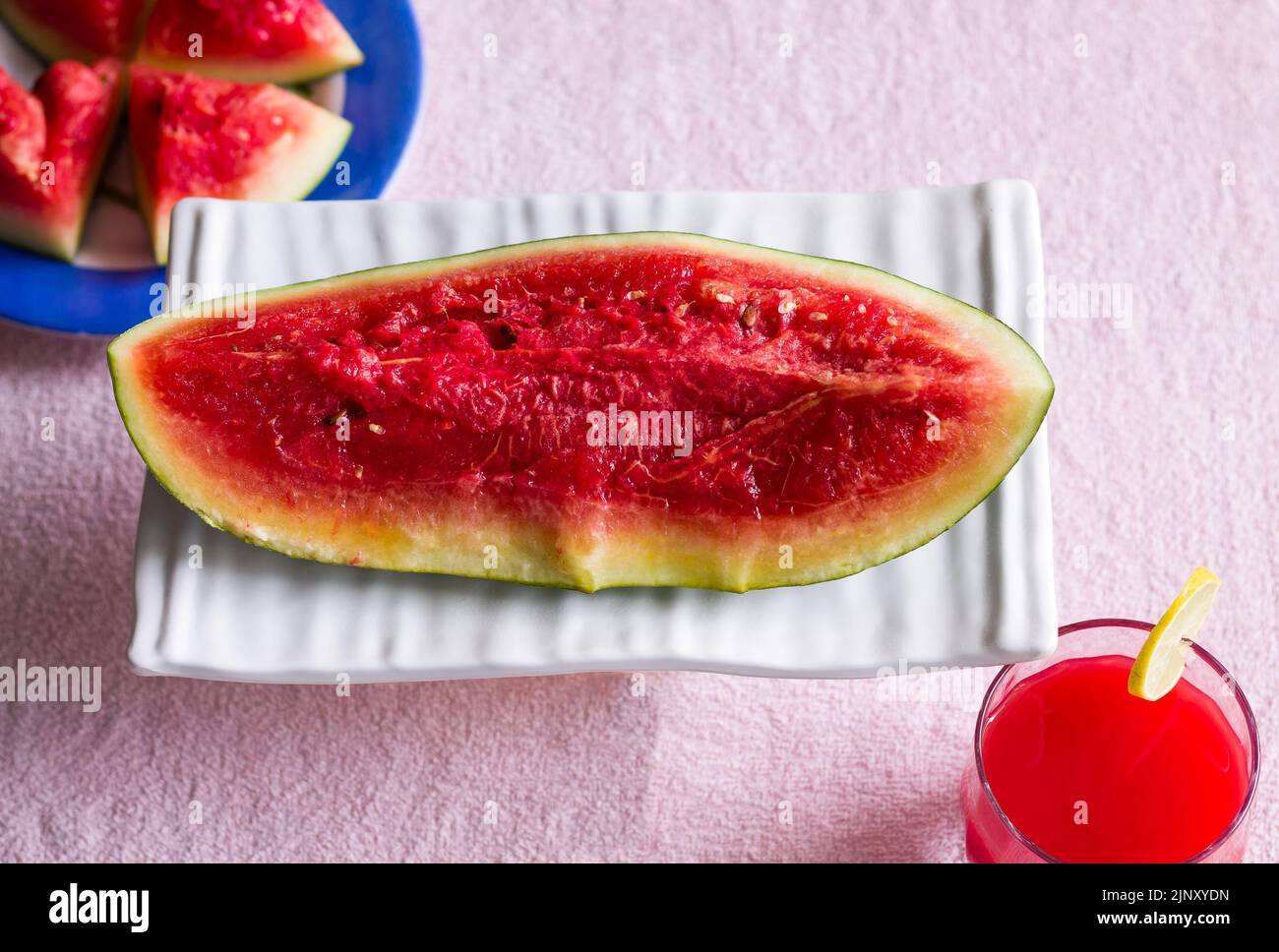 Verre simple de jus de fruit de pastèque réfrigéré. Sain mocktail frais garni avec une tranche de citron, isolé sur fond noir. Vue de dessus. Banque D'Images