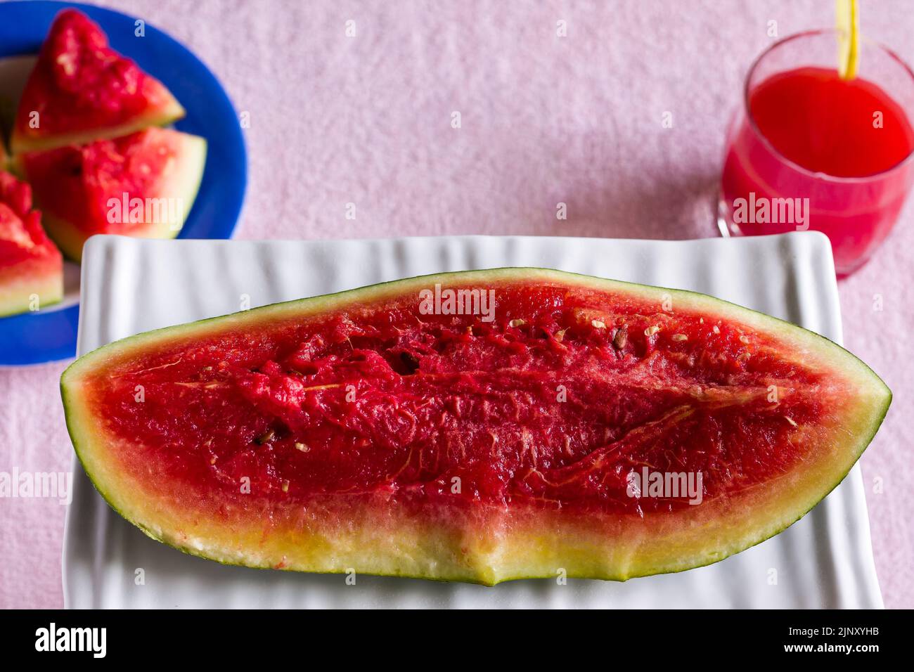 Verre simple de jus de fruit de pastèque réfrigéré. Sain mocktail frais garni avec une tranche de citron, isolé sur fond noir. Vue de dessus. Banque D'Images