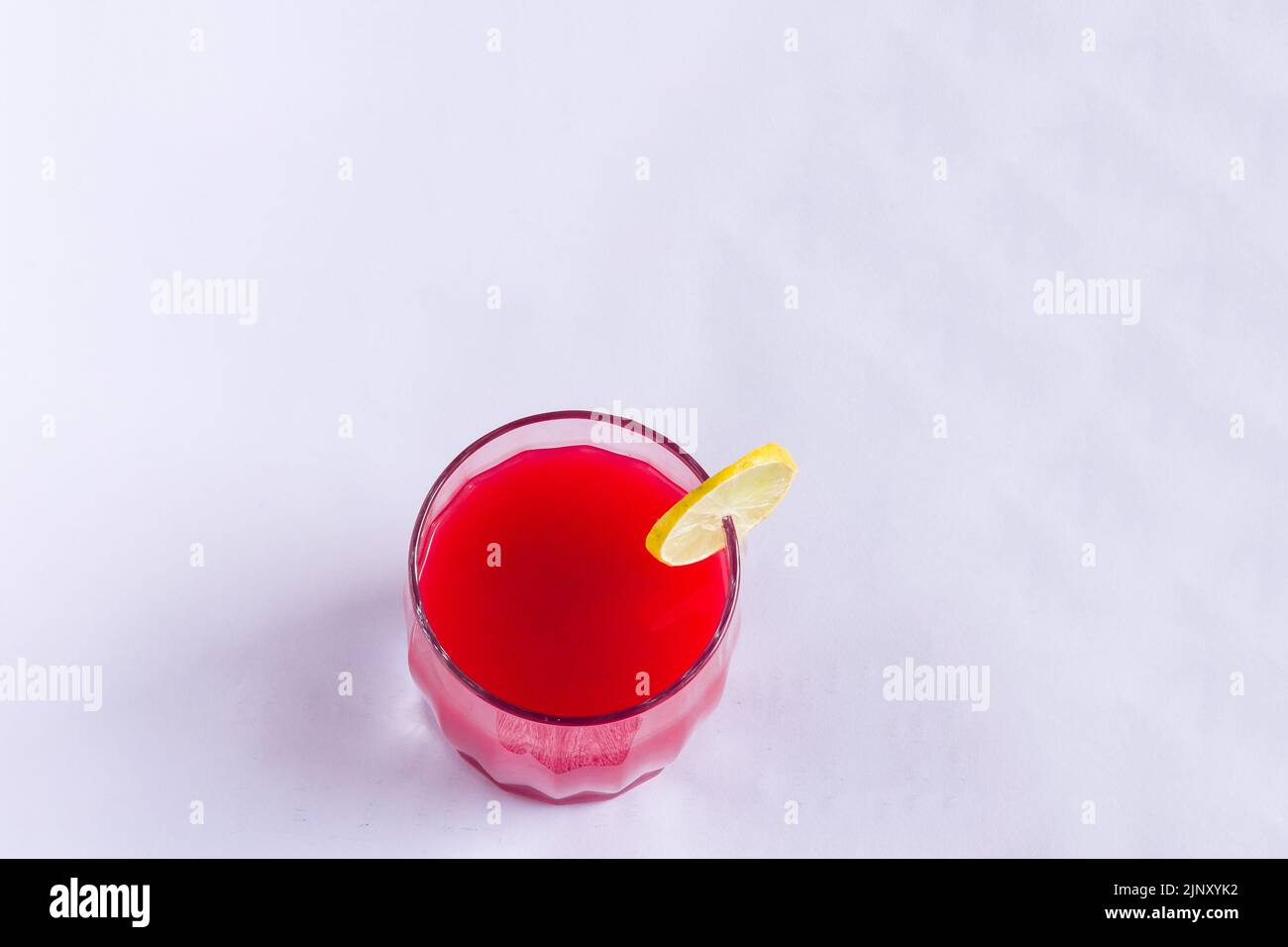Verre simple de jus de fruit de pastèque réfrigéré. Sain mocktail frais garni avec une tranche de citron, isolé sur fond noir. Vue de dessus. Banque D'Images