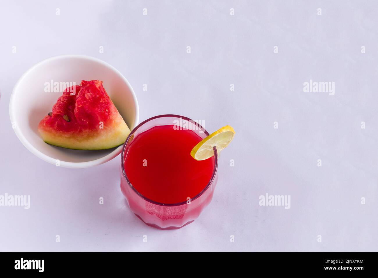 Verre simple de jus de fruit de pastèque réfrigéré. Sain mocktail frais garni avec une tranche de citron, isolé sur fond noir. Vue de dessus. Banque D'Images