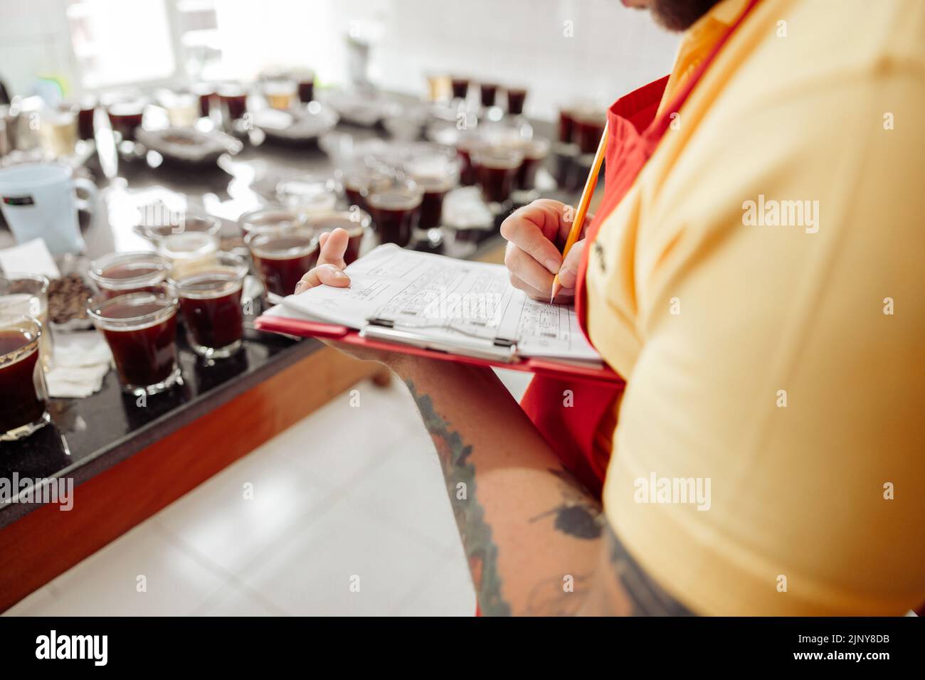 Photo rognée de l'homme prenant des notes pendant la dégustation du café Banque D'Images