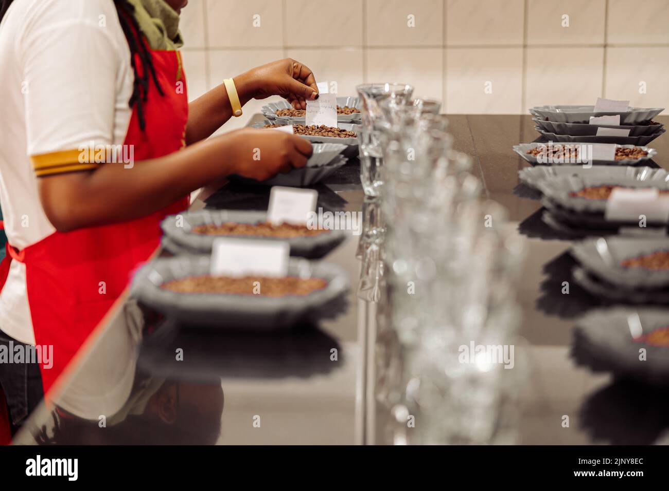 Femme plaçant des notes sur des assiettes avec du café pour la dégustation Banque D'Images