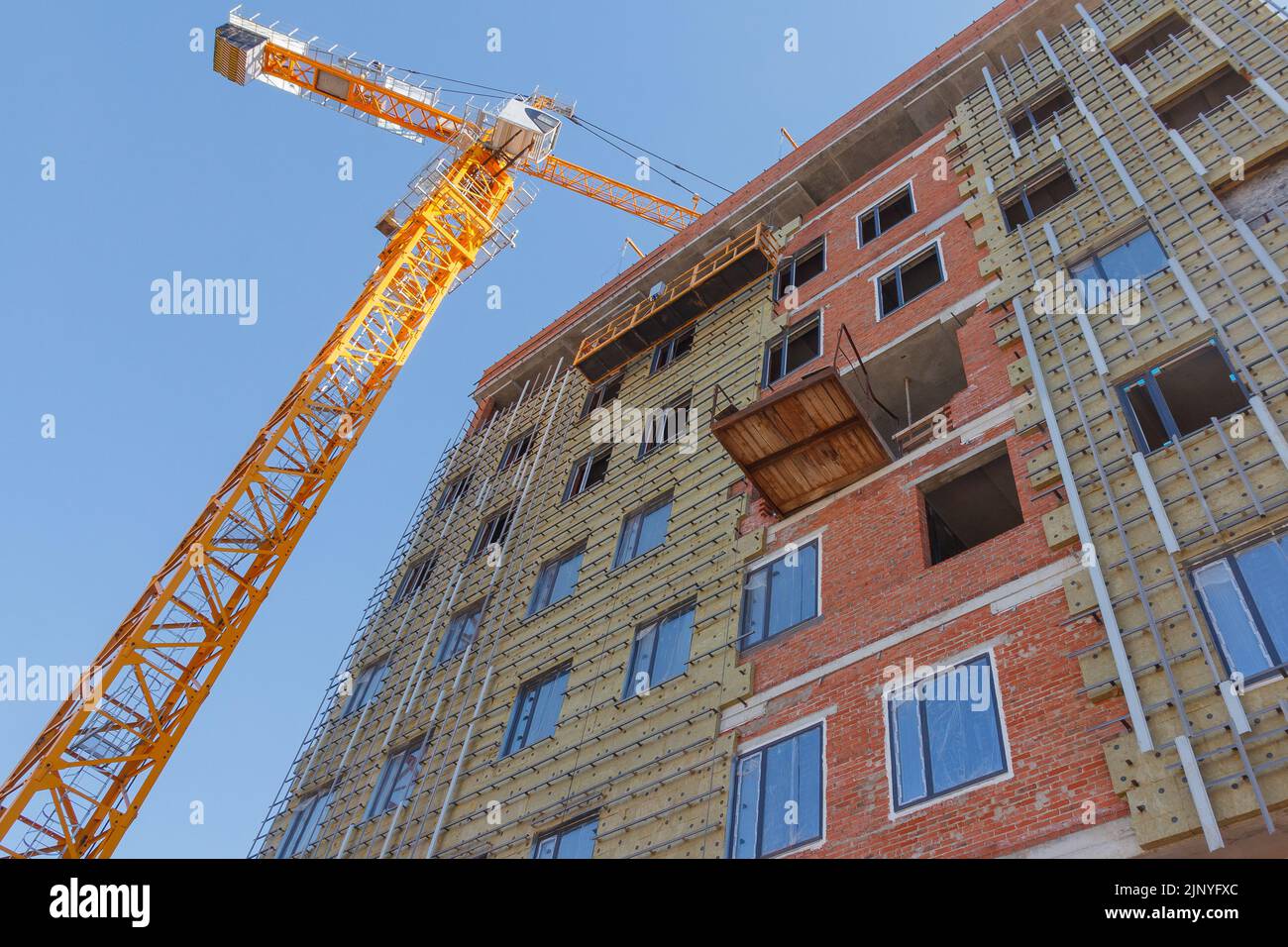 Construction d'un bâtiment résidentiel. Partie de l'immobilier urbain et de l'architecture. Façade d'un bâtiment résidentiel. Banque D'Images
