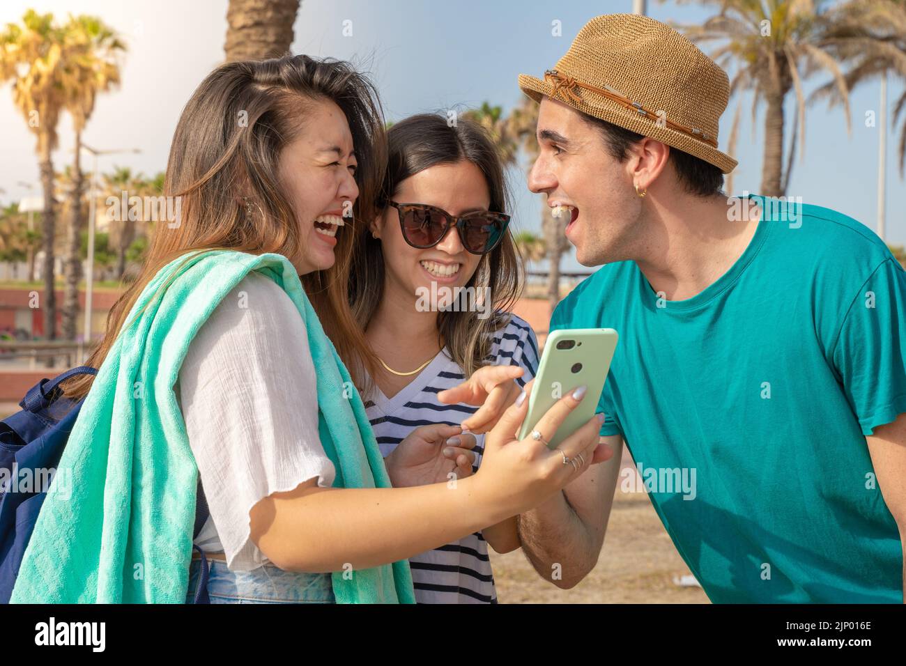 Groupe multiculturel de jeunes amis branchés qui rient en regardant le smartphone. Banque D'Images