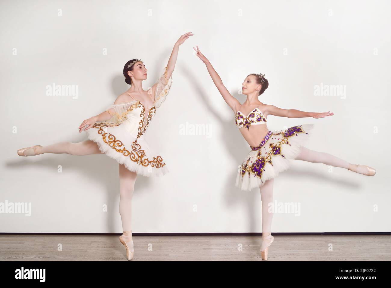 Deux ballerinas jeunes pratiquant le ballet pose sur un fond blanc Banque D'Images
