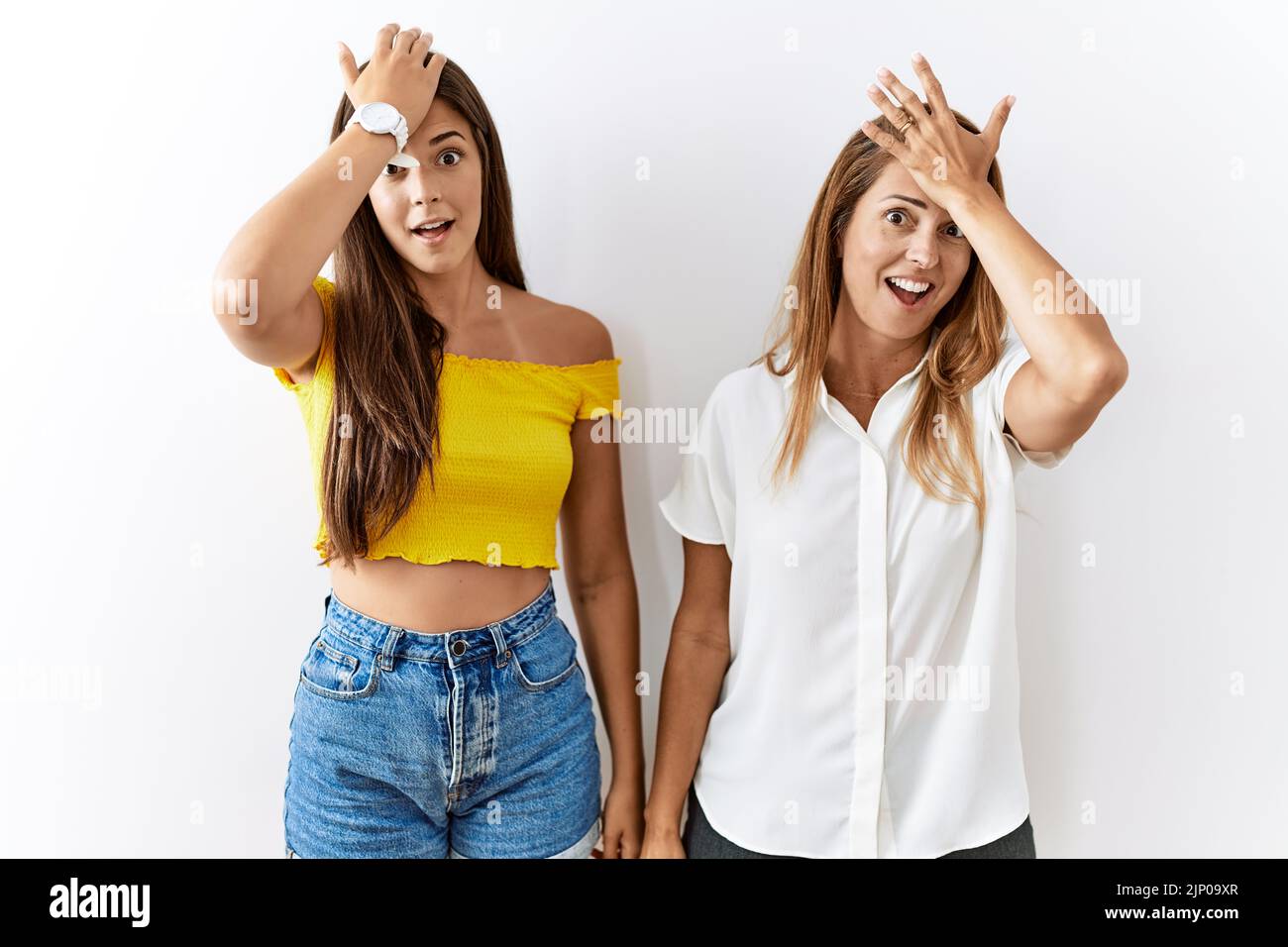 Mère et fille ensemble debout sur un fond isolé surpris avec la main sur la tête pour l'erreur, rappelez-vous l'erreur. oublié, mauvais mémoire co Banque D'Images Mère et fille ensemble debout sur un fond isolé surpris avec la main sur la tête pour l'erreur, rappelez-vous l'erreur. oublié, mauvais mémoire co Banque D'Images