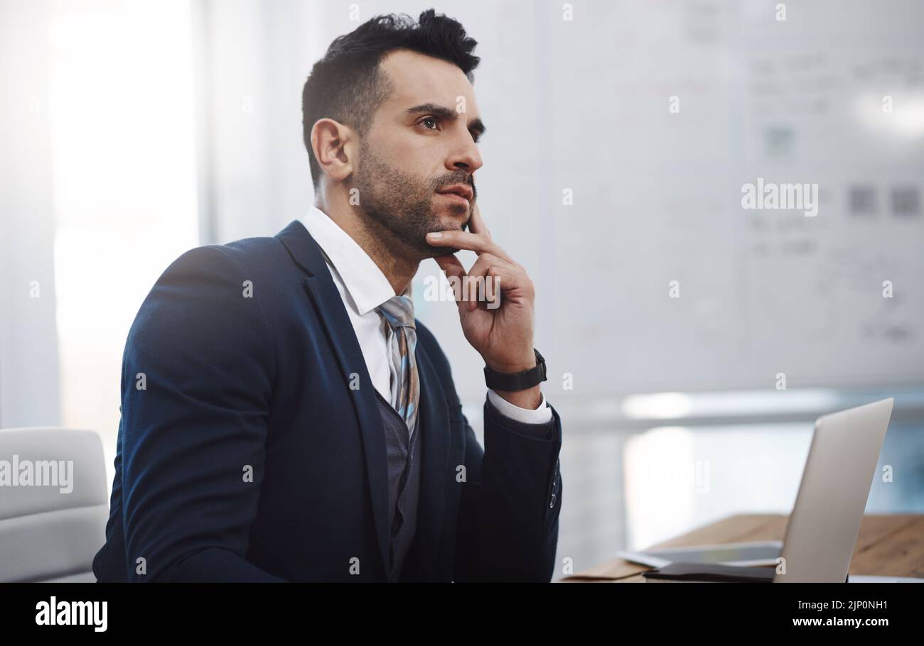 Une fois qu'il rêve d'un grand plan, il l'exécute plus grand : un jeune homme d'affaires qui a l'air réfléchi dans un bureau. Banque D'Images