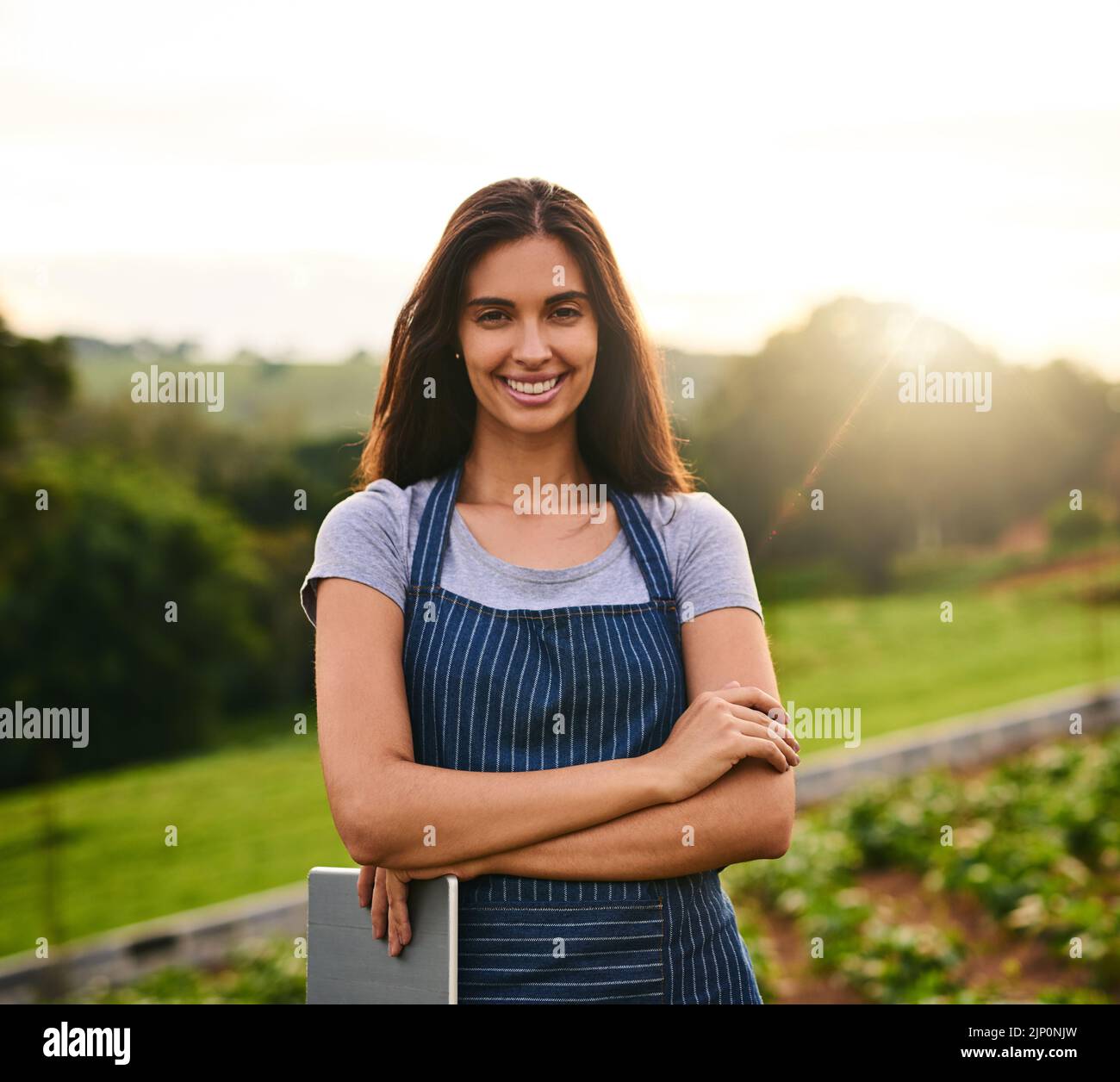 Je suis en train de diriger une ferme florissante. Portrait court d'une jeune femme attrayante debout avec ses bras pliés sur sa ferme. Banque D'Images