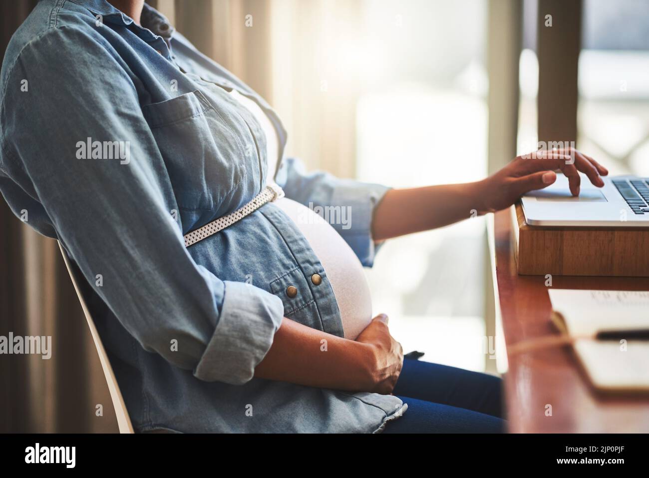 Parce que l'ambition ne se termine pas quand vous êtes enceinte. Une femme enceinte utilisant un ordinateur portable tout en travaillant à la maison. Banque D'Images