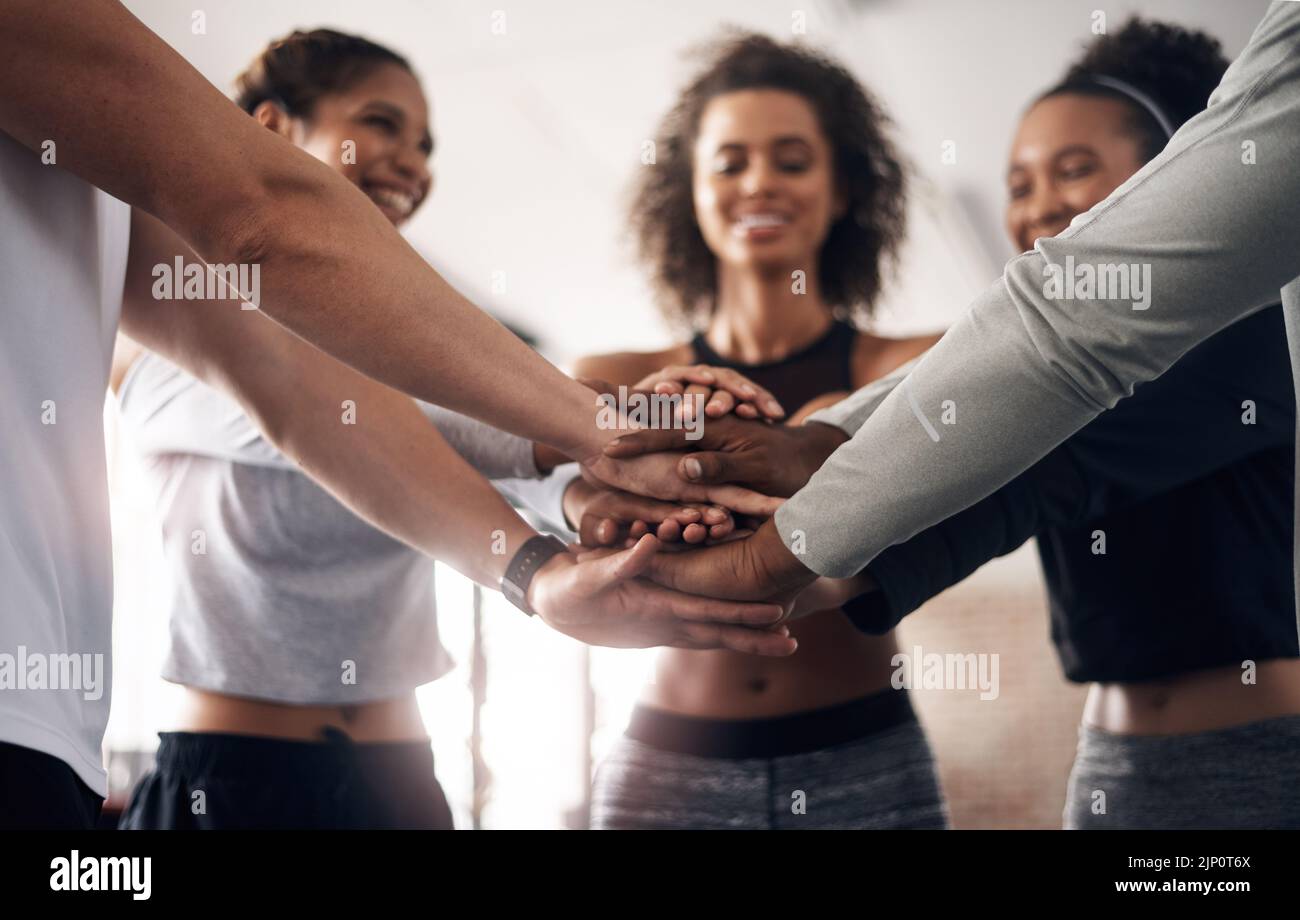 La bonne santé est la responsabilité de chacun. Un groupe de jeunes se joignant les mains en solidarité dans une salle de sport. Banque D'Images