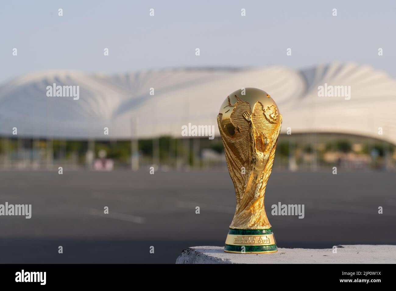 DOHA, QATAR - 14 AOÛT 2022 : trophée de la coupe du monde de la FIFA sur fond de stade Al Janoub au Qatar. Banque D'Images